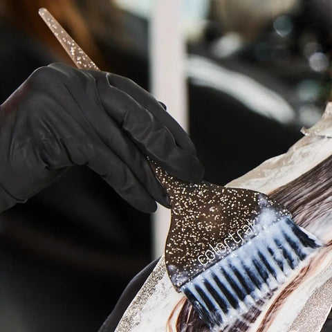 Colortrak Galaxy Glitter - Zestaw Szerokich Pędzelków do Farbowania w użyciu podczss farbowania włosów kobiety, pędzel trzymany jest w dłoni kobiety w rękawiczkach nitrylowych