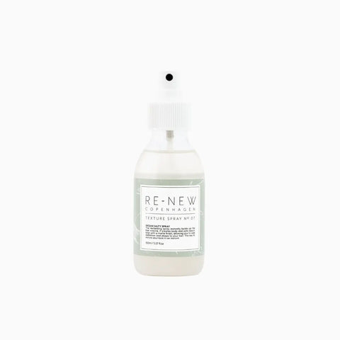 Przezroczysty pojemnik z białą etykietą zawierający spray teksturyzujący RE-NEW Copenhagen, Texture Spray nr 07, na białym tle.